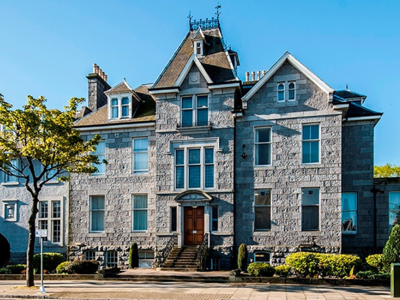 Cowdray Club Care Home, a historic building framed by greenery