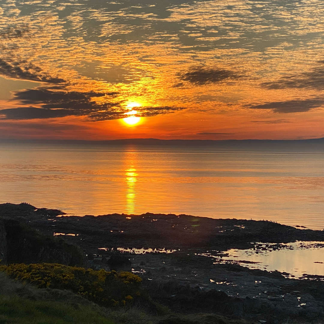 Scenic coastal views from the grounds of Malin Court Care Home, - the sun sets over the water 