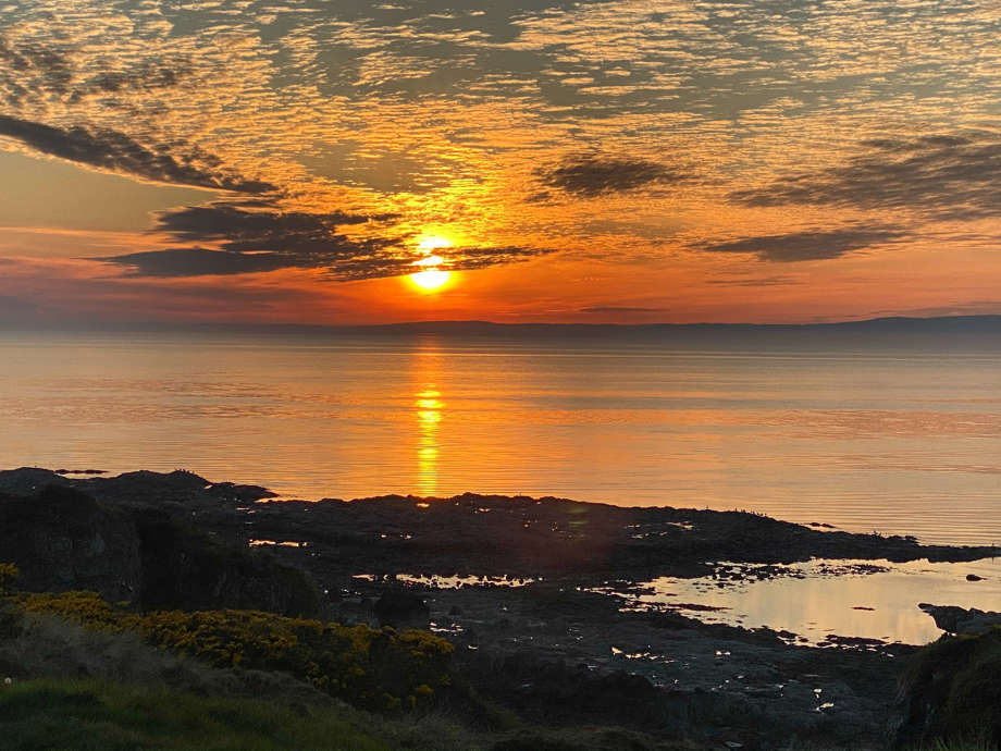 Scenic coastal views from the grounds of Malin Court Care Home, - the sun sets over the water 