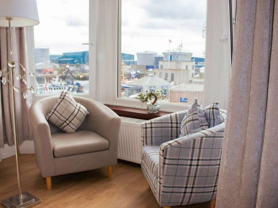 Peaceful window seat in a care home bedroom. The window offers a view of the harbour. 