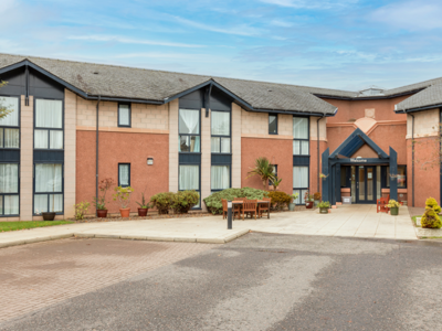 Care home exterior, showing the homes entrance and outdoor/seating area 