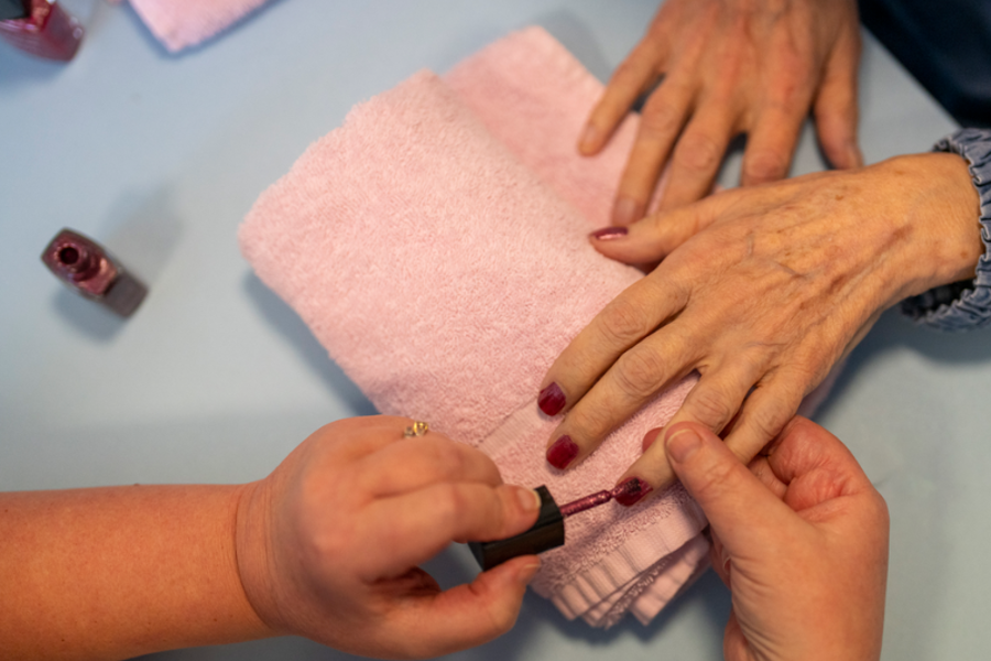 A staff member paints a care home residents nails