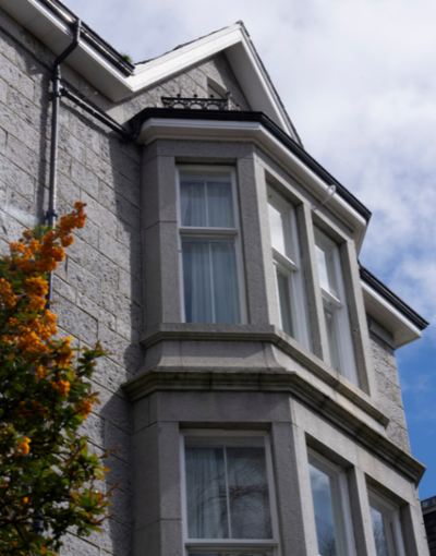 Exterior of Cowdray Club building from the garden. A period, grey brick property 