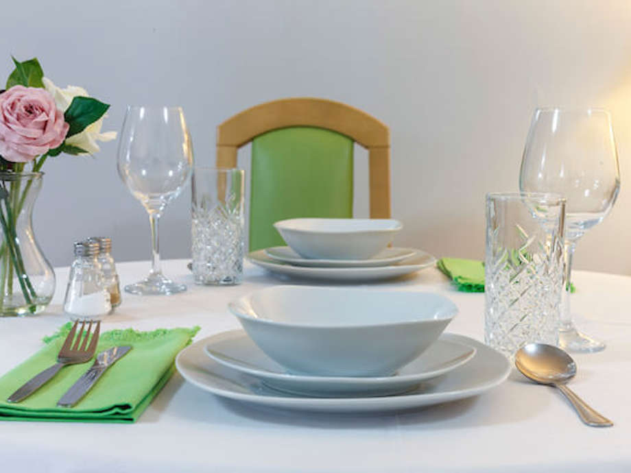 Plates, silverware, and napkins are neatly arranged on the table, ready for diners