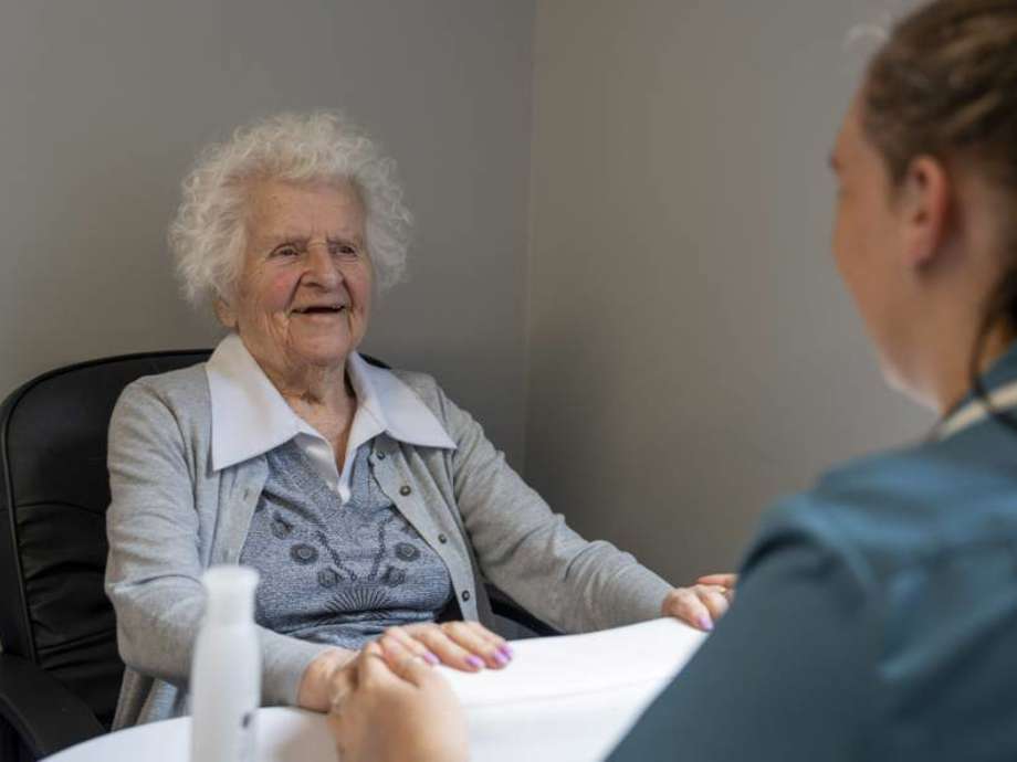 Care resident receives a manicure and smiles contentedly