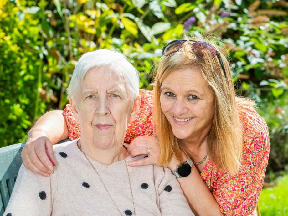 A family portrait of a visiting relative and their loved one enjoying time in the garden 