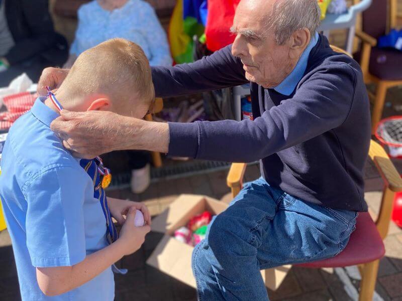 Thomas Bow with St John Paul II Primary School pupil at care home sports day