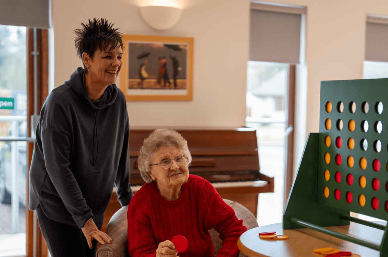 A resident and their relative enjoying a game of tabletop connect four