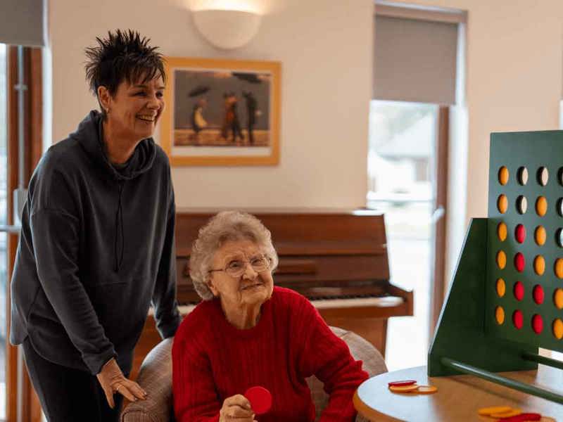 A resident and their relative enjoying a game of tabletop connect four