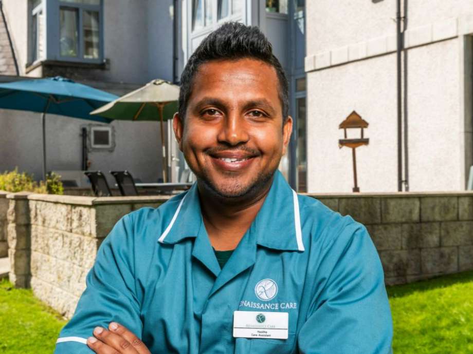 A staff member smiles outside the care home