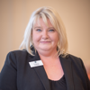 Headshot of care home manager, Liz Macrae. She has blonde hair, and is wearing a black blouse and blazer